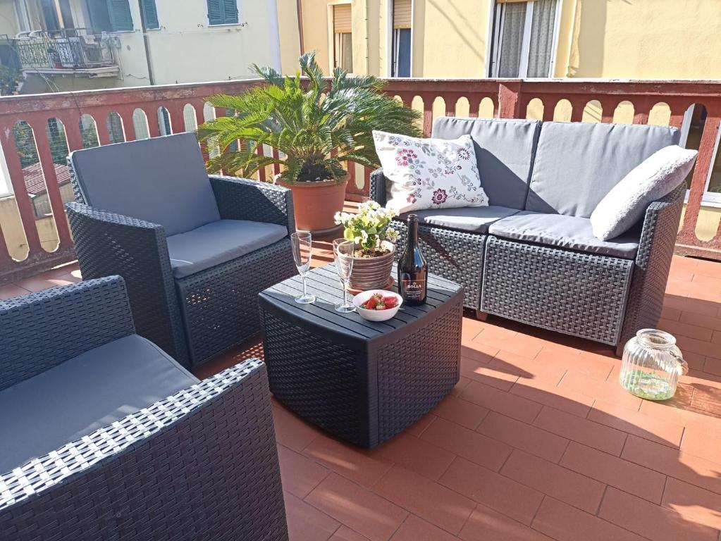 un patio con 2 sedie in vimini e un tavolo di La Casa di Ele, parcheggio privato gratuito a La Spezia