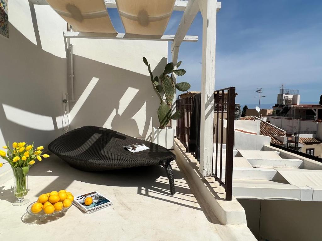 a black chair sitting on the side of a balcony at Terme Luxury Suite in Taormina