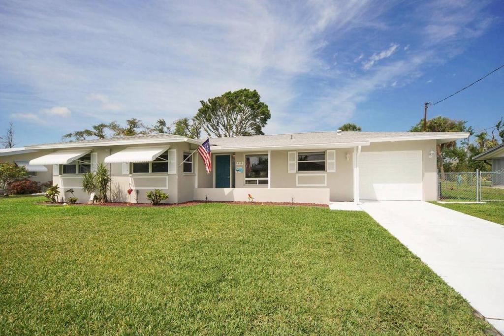 a white house with a flag in a yard at Villa Holiday Sunrise II in Cape Coral