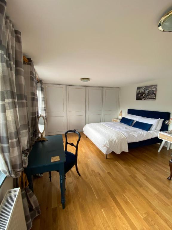 a bedroom with a bed and a table and a desk at Zen Cottage, Cheltenham in Cheltenham