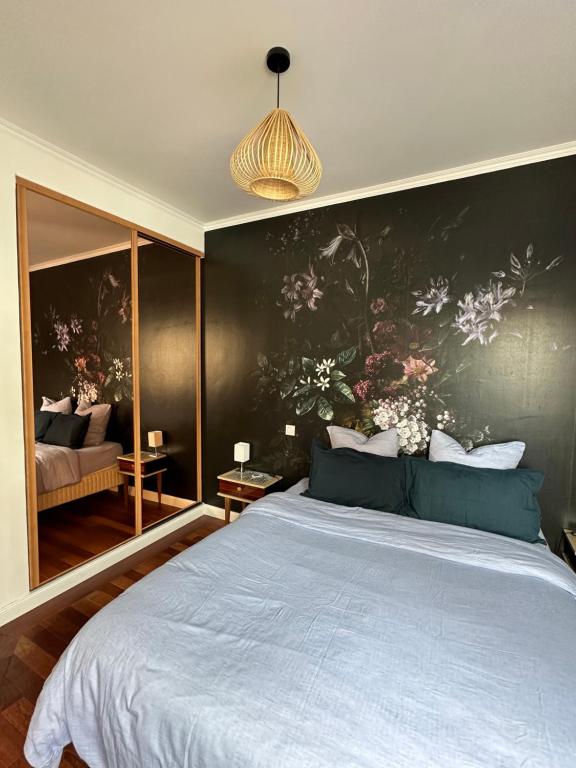 a bedroom with a large bed with a painting on the wall at L'Emperador in Reims