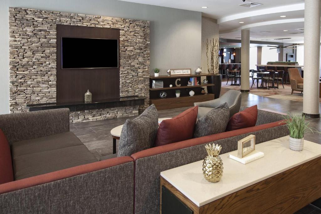 a living room with a couch and a tv at Courtyard by Marriott Valdosta in Valdosta