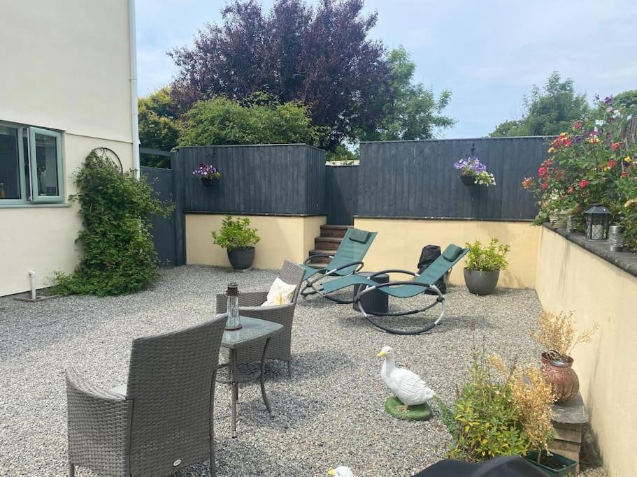 a patio with chairs and a table and a fence at Rural cosy retreat for two near Port Isaac in Delabole