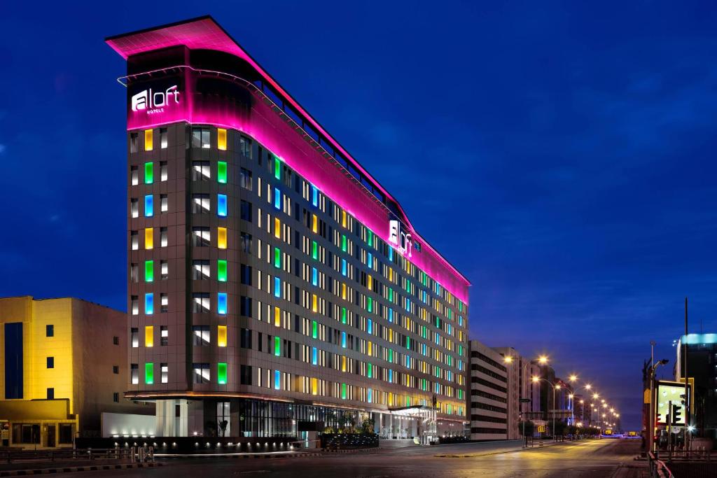 リヤドにあるAloft Riyadh Hotelのライトアップされたホテルの建物