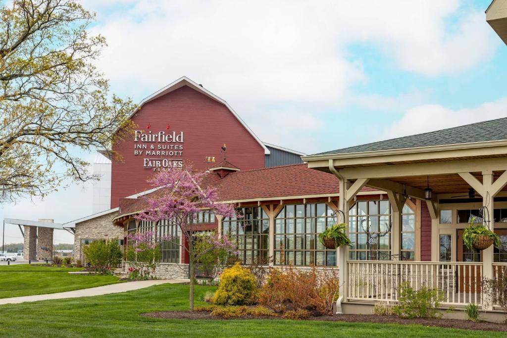 un granero rojo con una señal en el costado. en Fairfield Inn & Suites by Marriott Fair Oaks Farms en Fair Oaks