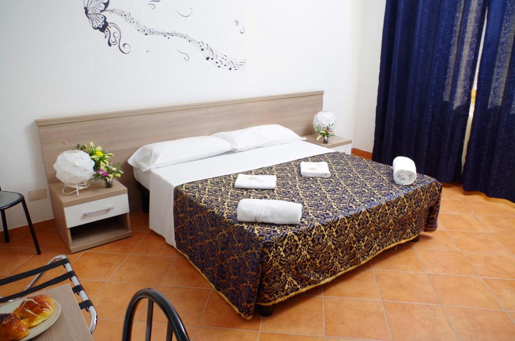 una camera da letto con un letto e un tavolo con asciugamani di Hotel Centrale a Milano
