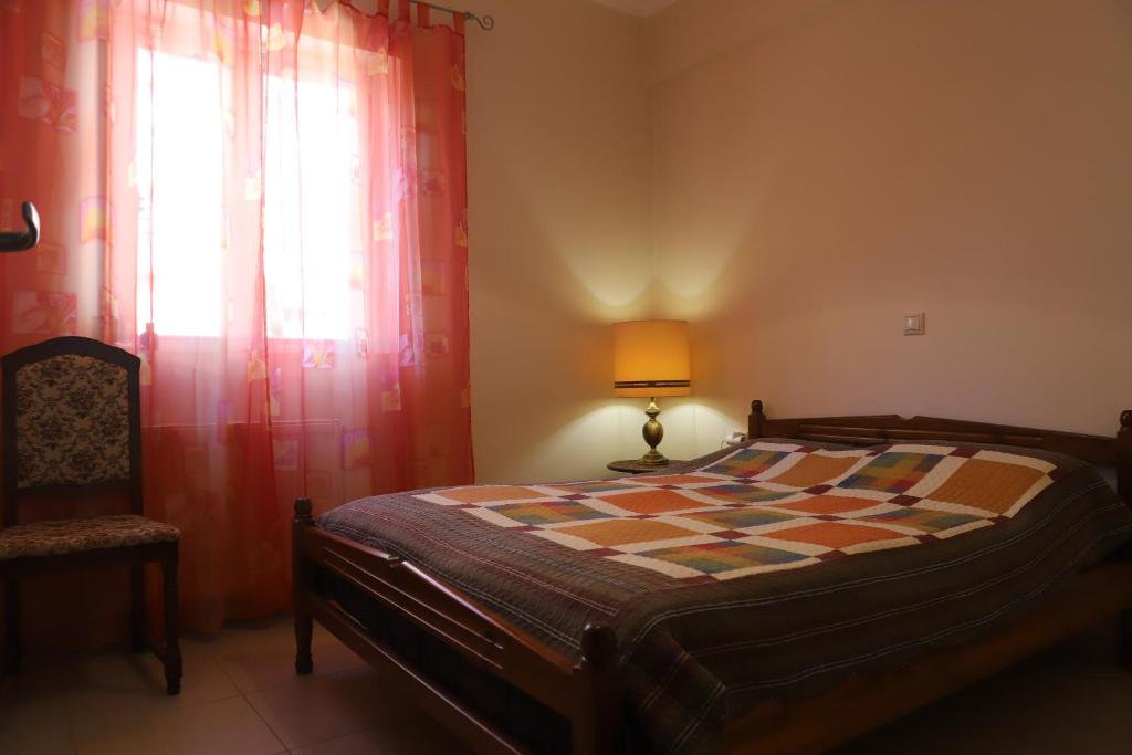 um quarto com uma cama, um candeeiro e uma janela em Dimitri's House em Nafplio