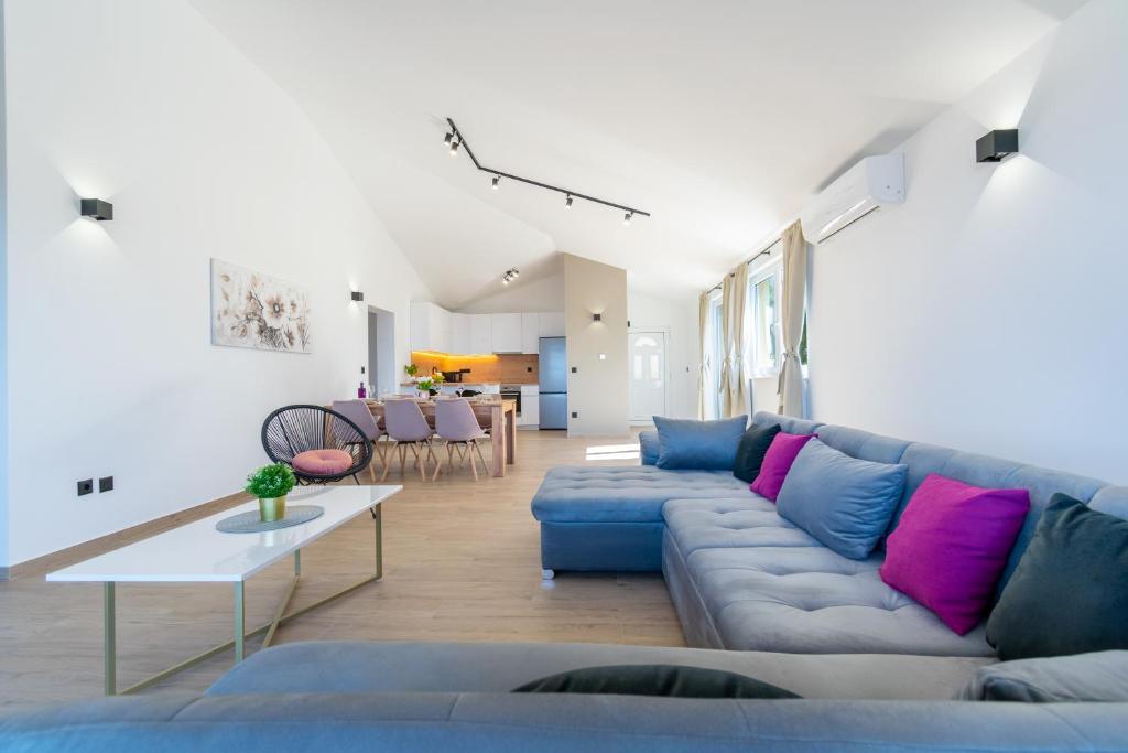 a living room with a blue couch and a table at Penthouse Nensi in Baška Voda