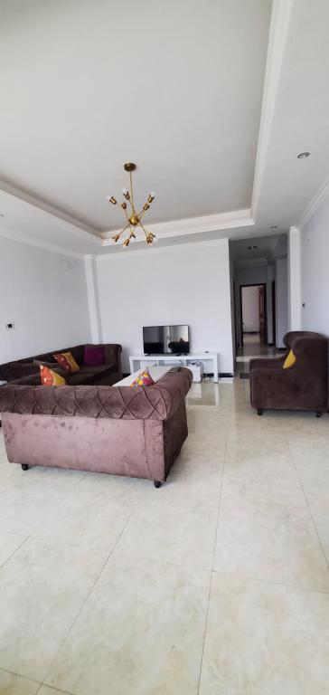 a living room with two couches and a ceiling at Cozy 3bedrooms Apartment in Addis Ababa