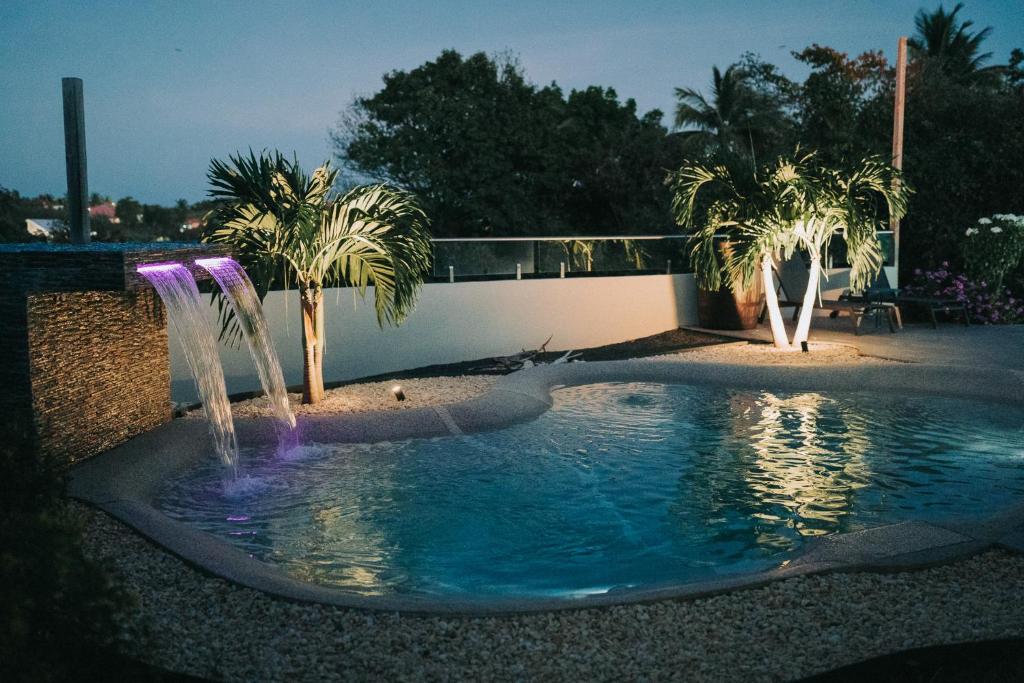 a pool with two water fountains in a yard at Villas Riviera F4, Le Helleux, calme, lagon privé in Sainte-Anne