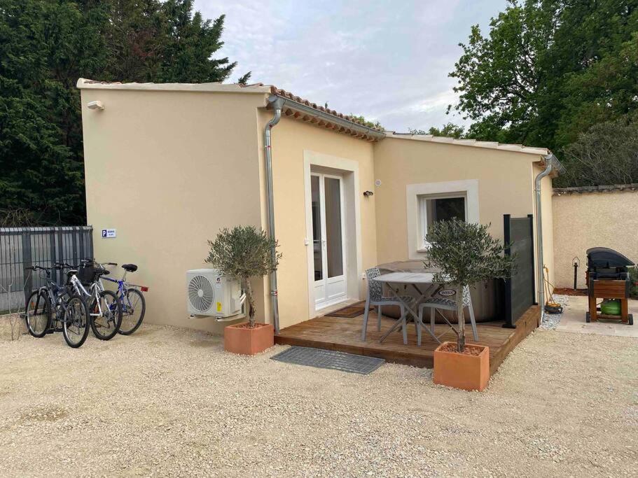 une petite maison avec une table et des vélos garés à côté dans l'établissement Maison gîte avec spa privé & piscine, à Mondragon