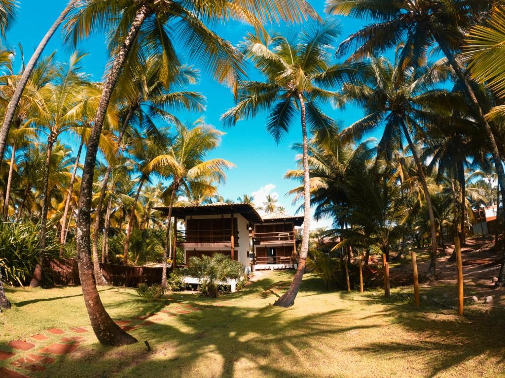a resort with palm trees in front of it at Bangalô Patuá in Barra Grande