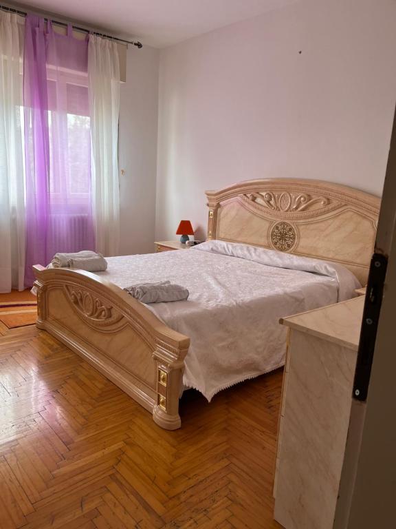 ein Schlafzimmer mit einem großen Bett und Holzboden in der Unterkunft Stanze private in appartamento in Udine