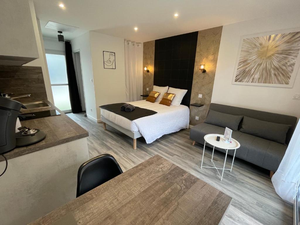 Habitación de hotel con cama y sofá en Jardin privé 1 en La Ravoire