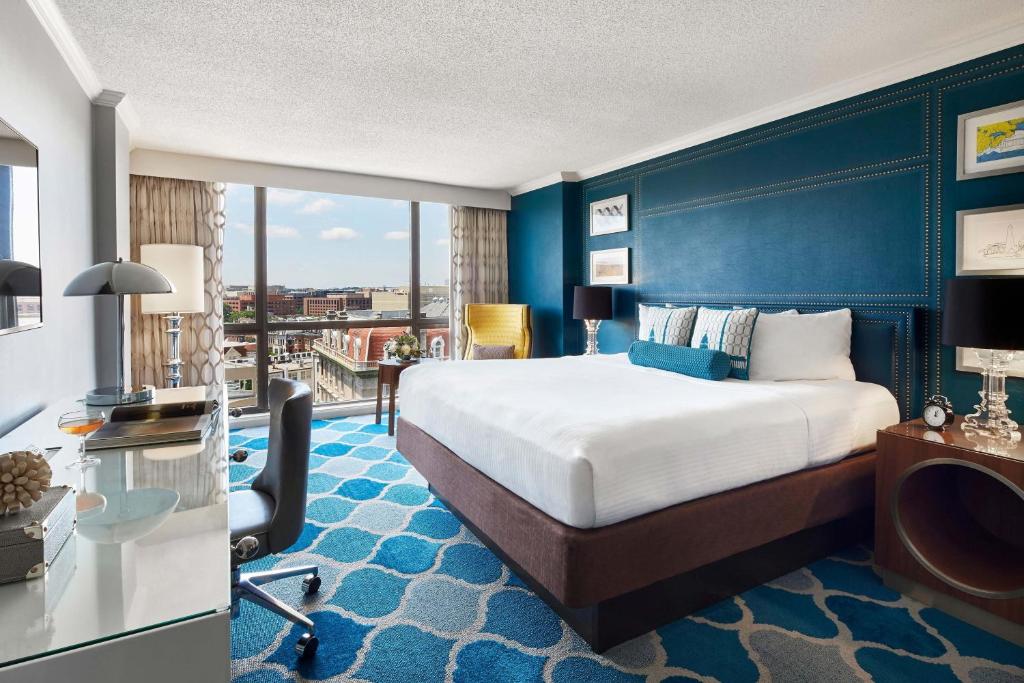 een hotelkamer met een groot bed en een bureau bij The Ven at Embassy Row, Washington, D.C., a Tribute Portfolio Hotel in Washington