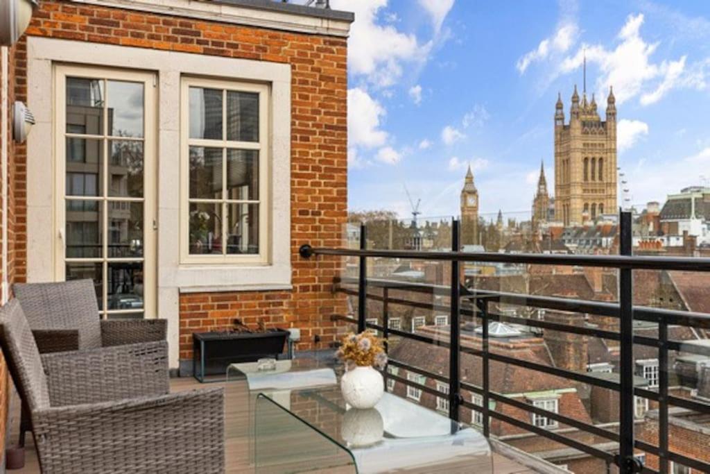 倫敦的住宿－Westminster Big Ben Apartment，阳台设有玻璃桌,享有城市美景。