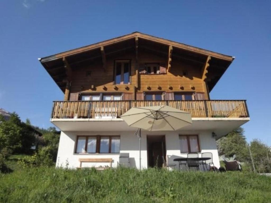 a house with an umbrella in front of it at Chalet Stefanino, 3 12 Zimmer in Bellwald
