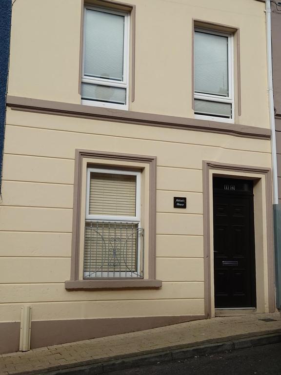 a building with two windows and a door at Helens House Derry City Centre Remarkable 3-Bed in Derry Londonderry