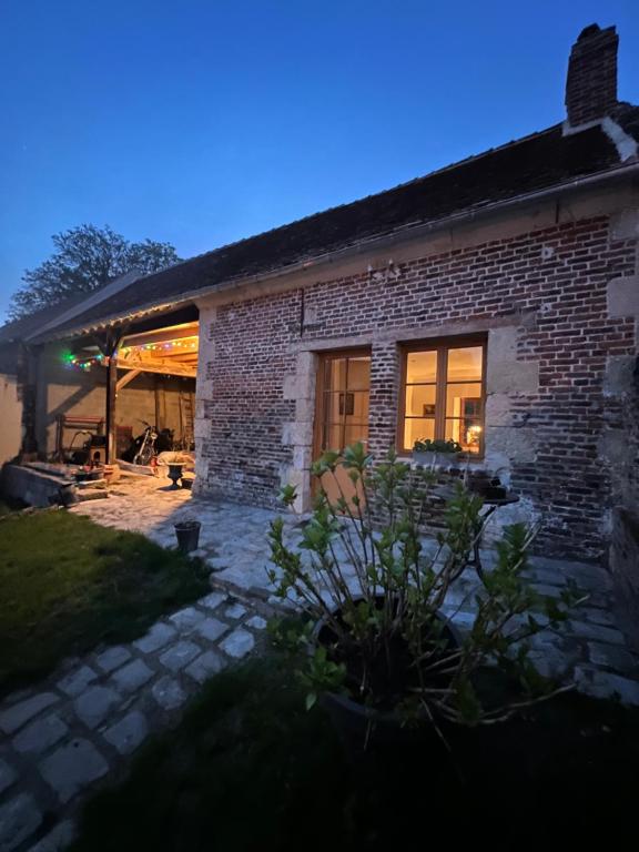een stenen huis met een patio in de nacht bij Studio du Mont des Ormes in Monchy-Humières
