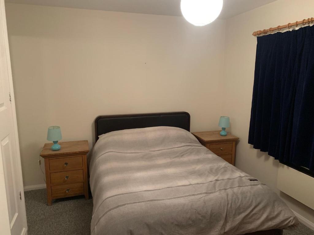 a small bedroom with a bed and two night stands at Sovereign Harbour Eastbourne Rooms in a Holiday Home in Eastbourne