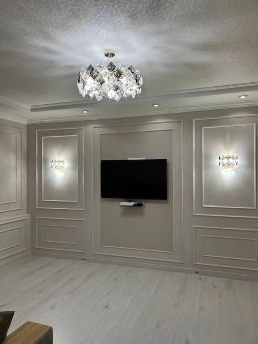 uma sala de estar com uma televisão de ecrã plano na parede em Miracle Apartment em Samarkand