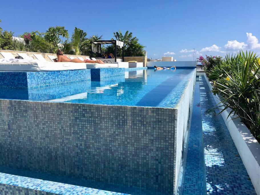 a pool at a resort with blue tiles at Estudio exclusivo in The City - TOP amenidades! in Playa del Carmen
