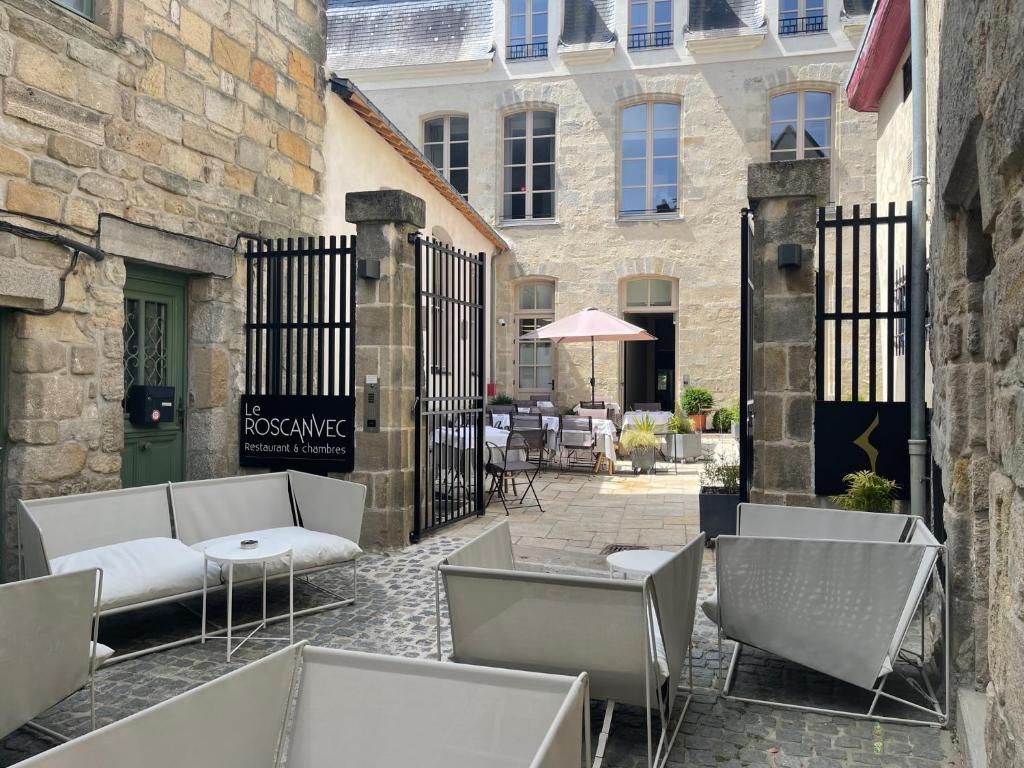 a patio with chairs and tables in front of a building at Le Roscanvec in Vannes