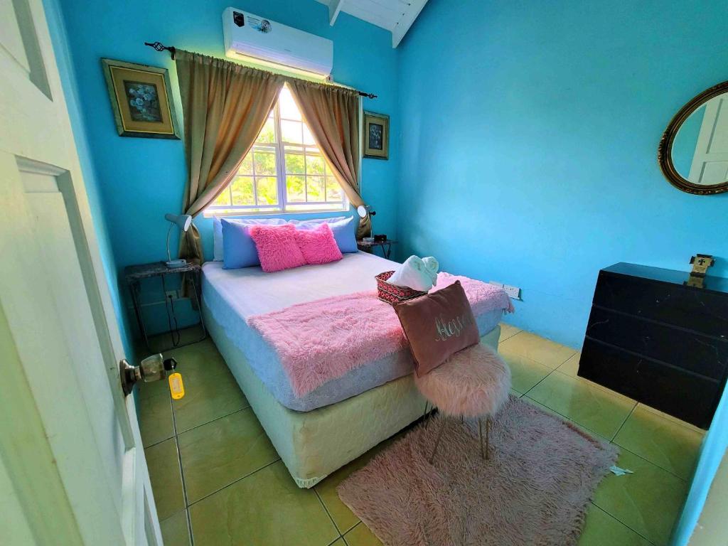 ChoiseulComfort Suites Three Bedroom Apartment的一间卧室配有一张带粉色床单的床和一扇窗户。