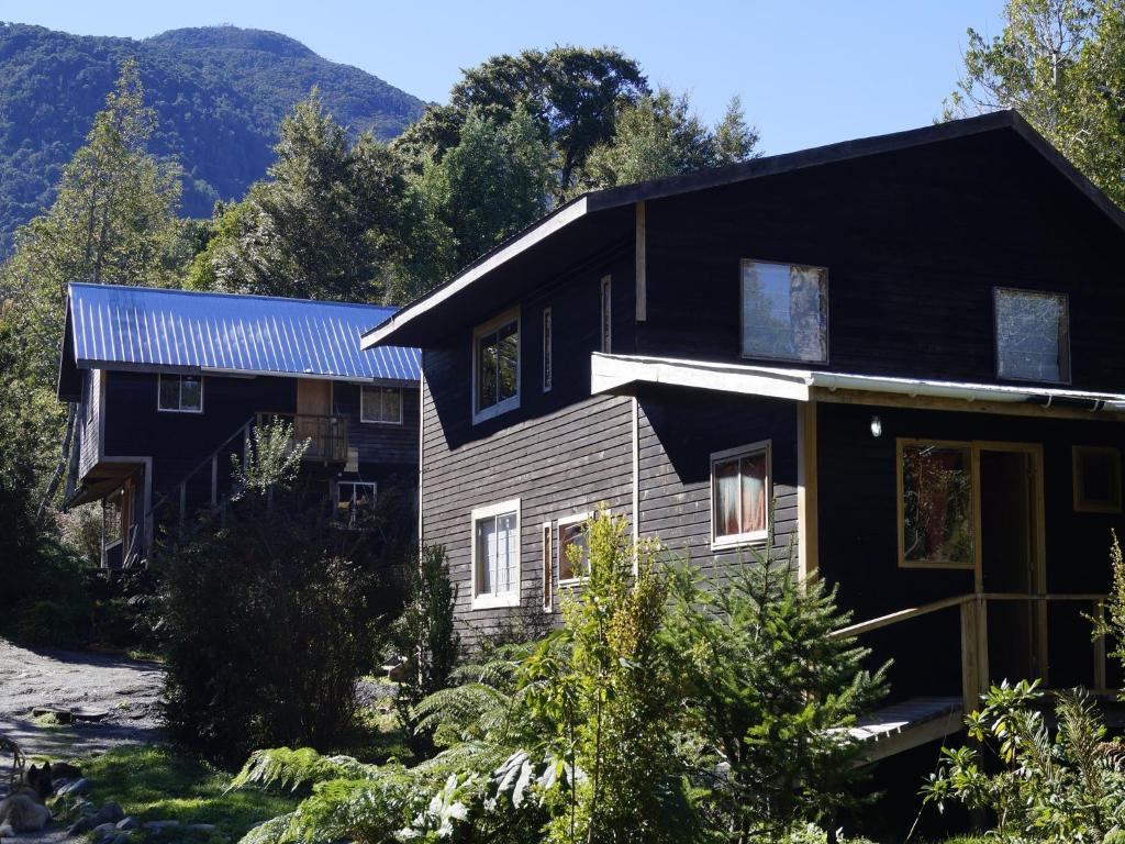 una casa con una casa negra y gris en Posada de Expediciones Kahuel, en Chaitén