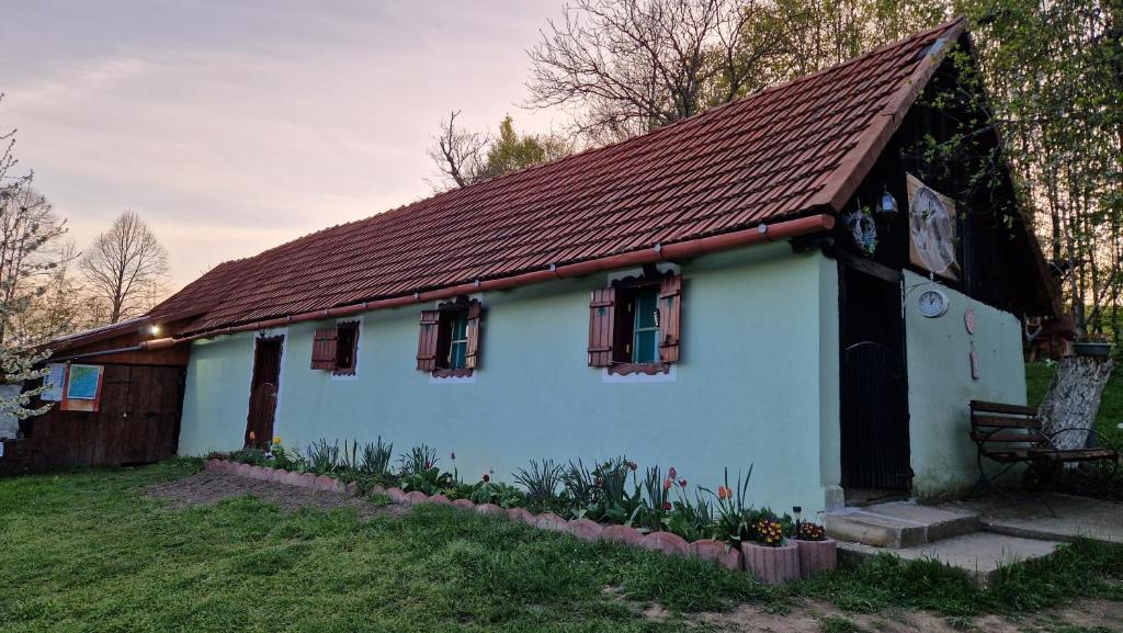 ein kleines weißes Haus mit braunem Dach in der Unterkunft La sălaşul fermecat în Cheile Carasului in Iabalcea