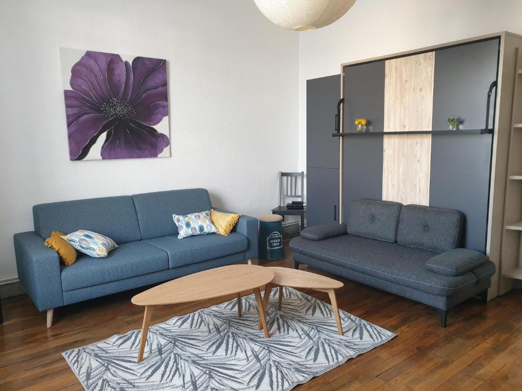 een woonkamer met een blauwe bank en een tafel bij B5 - Mont St Martin - RDC in Mont-Saint-Martin
