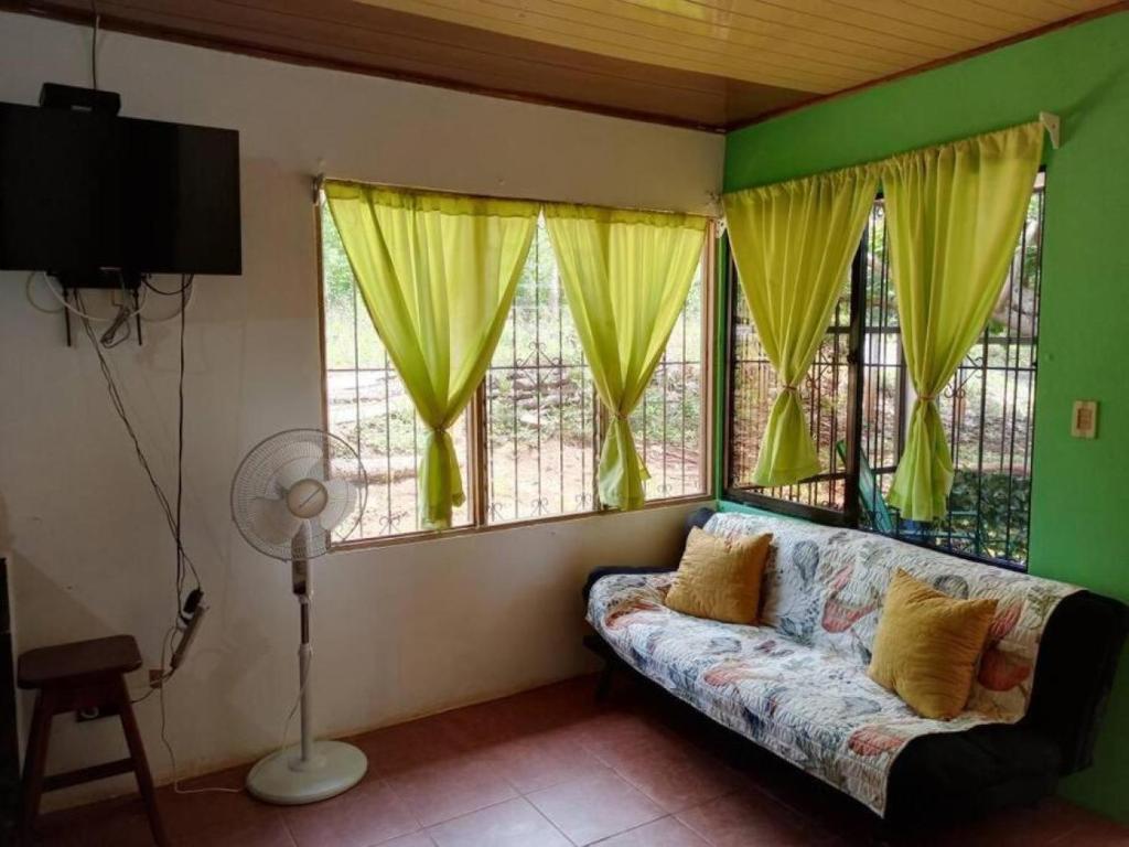 uma sala de estar com um sofá e algumas janelas em La casita JSL 