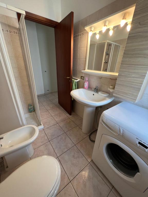 uma casa de banho com uma máquina de lavar roupa e um lavatório em Waterfront Gallipoli 150 mt dal mare em Gallipoli