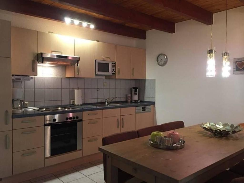 cocina con mesa y fogones horno superior en Ferienhaus in Feriendorf Silbersee mit Offenem Kamin en Frielendorf