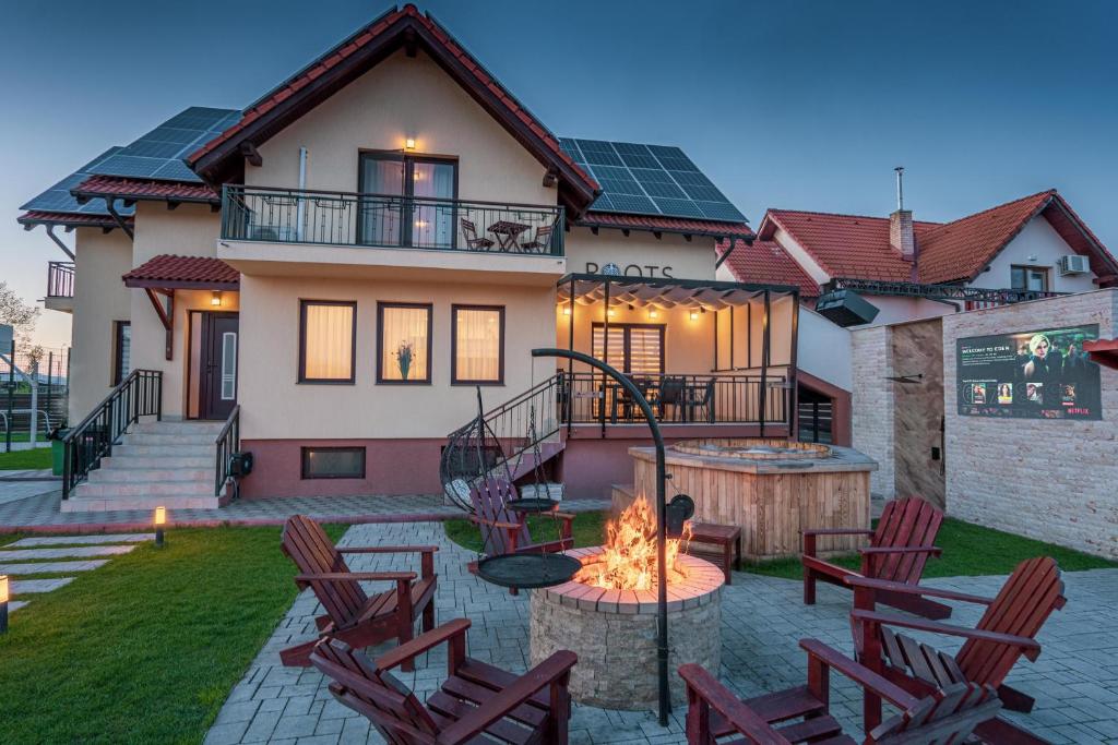 a house with a fire pit in the yard at Roots Villa Redwood in Braşov