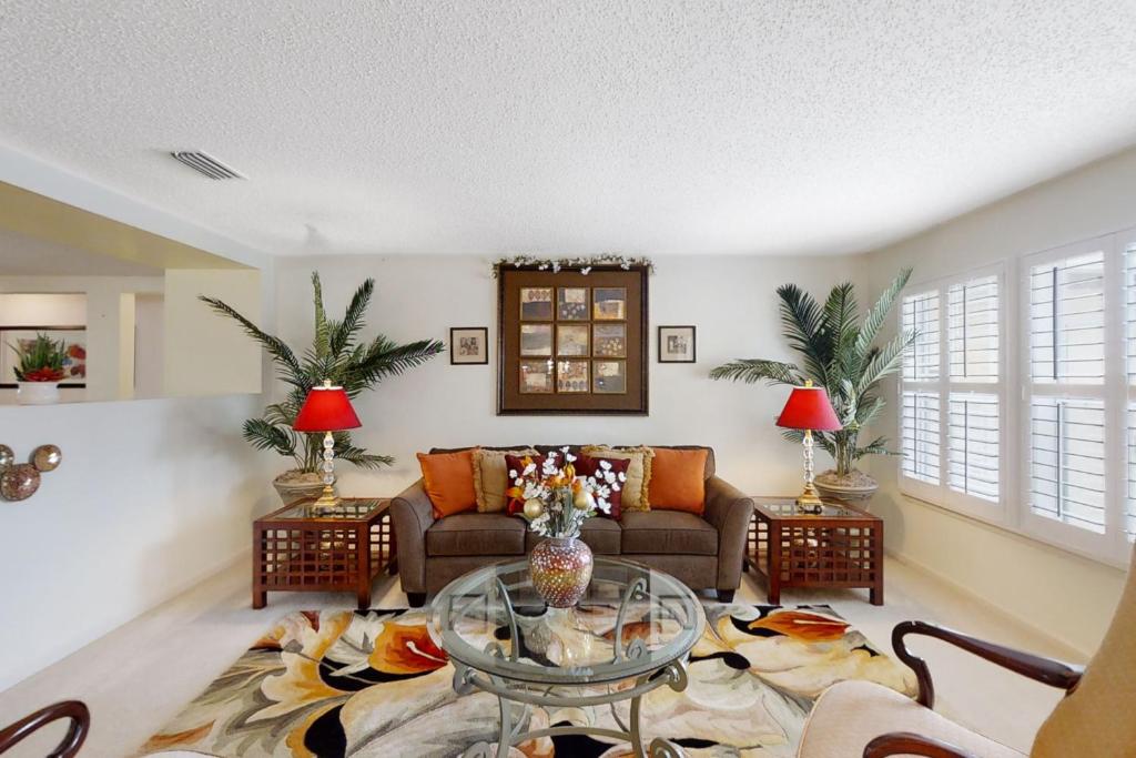 uma sala de estar com um sofá e uma mesa de vidro em The Home on Tyson Lake Drive em Jacksonville