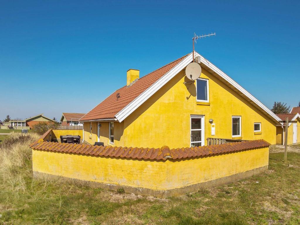 Nørre Vorupør的住宿－Four-Bedroom Holiday home in Thisted 7，田野上红色屋顶的黄色房子