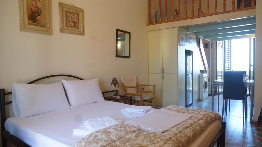1 dormitorio con 1 cama con almohadas blancas en Annas Sea & City, en Palaiochóra