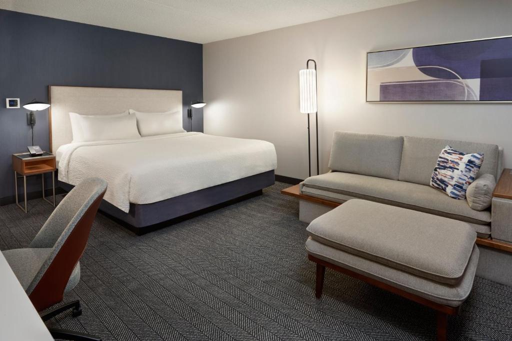 pokój hotelowy z łóżkiem i kanapą w obiekcie Courtyard by Marriott Toronto Mississauga/Meadowvale w mieście Mississauga