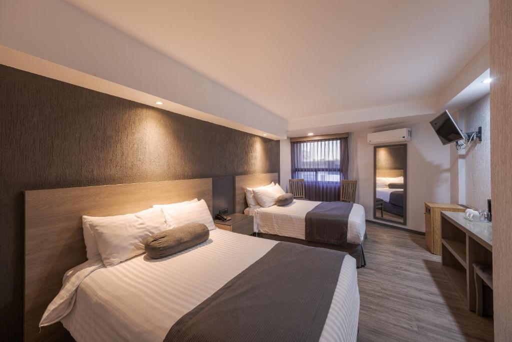 Hotel Malibu في غواذالاخارا: غرفة فندقية بسريرين ومغسلة