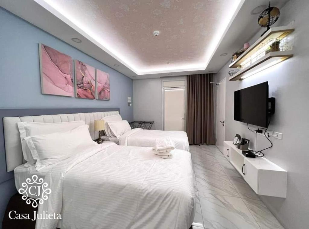 um quarto de hotel com duas camas e uma televisão de ecrã plano em Casa Julieta Boutique Hotel em Davao