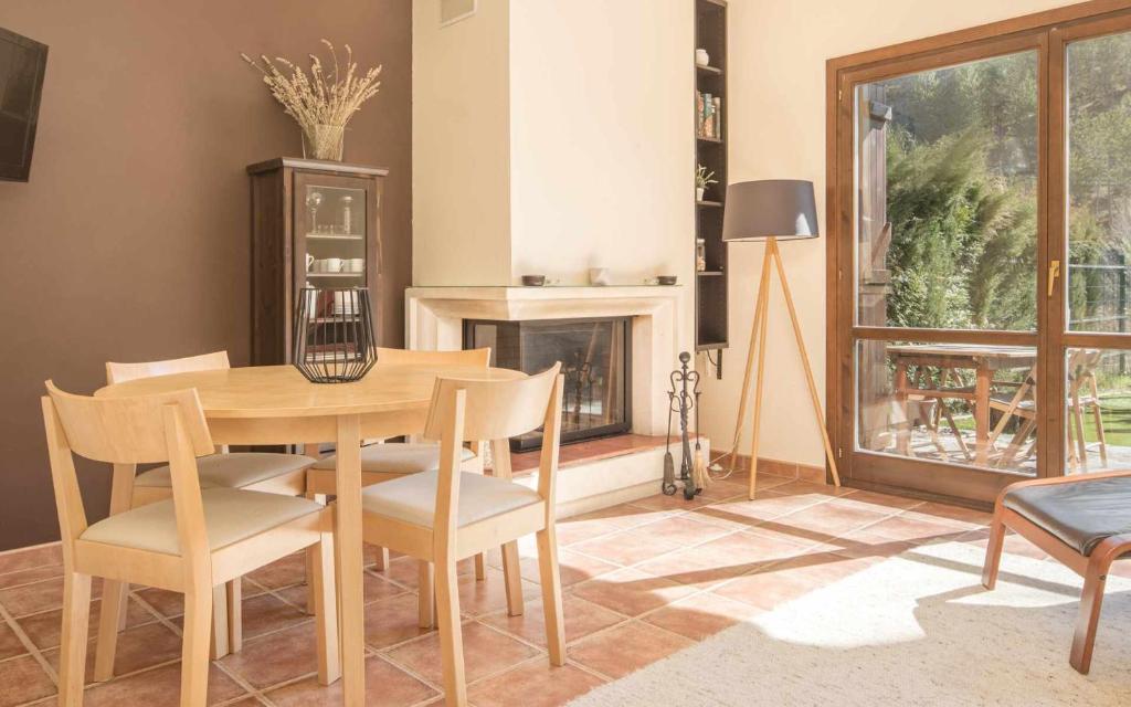 a dining room with a table and chairs and a fireplace at Chalet El Molino de Castiello in Castiello de Jaca