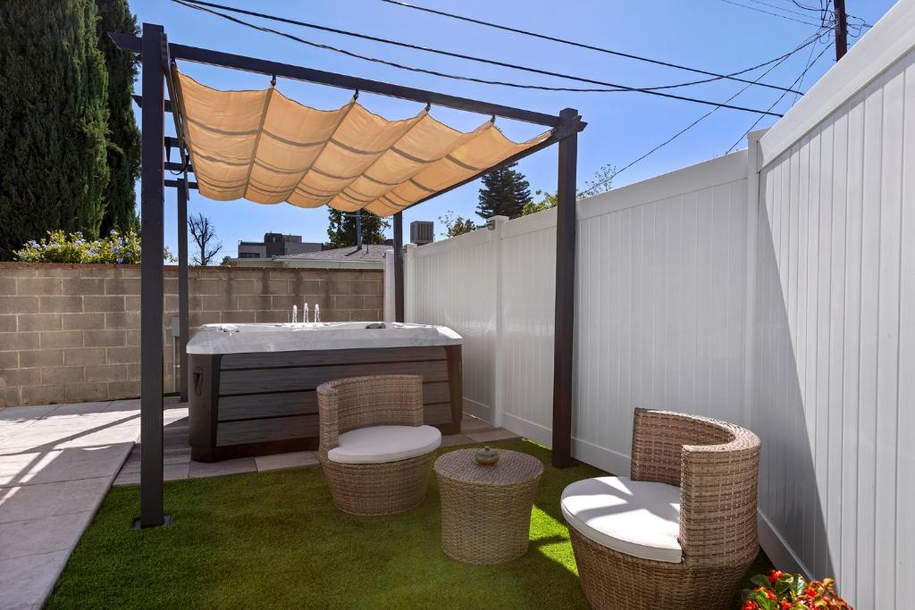 un patio con cenador, sillas y mesa en Adorable 3 bedroom with Jacuzzi & more, en Los Ángeles