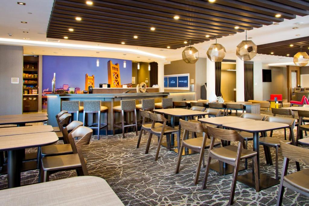 Un restaurante con mesas y sillas y un bar. en SpringHill Suites by Marriott West Sacramento, en West Sacramento