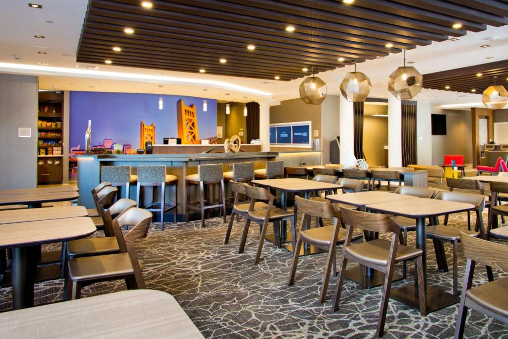 a restaurant with tables and chairs and a bar at SpringHill Suites by Marriott West Sacramento in West Sacramento