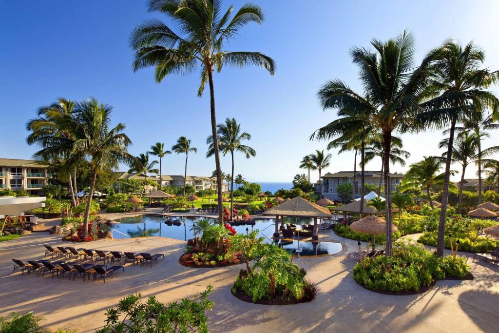 - une vue aérienne sur un complexe avec une piscine et des palmiers dans l'établissement The Westin Princeville Ocean Resort Villas, à Princeville