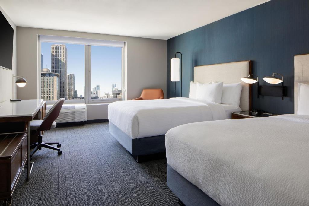 a hotel room with two beds and a desk and a window at Courtyard by Marriott Chicago Downtown/River North in Chicago