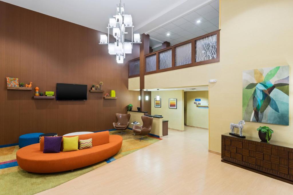 eine Lobby eines Krankenhauses mit einer orangefarbenen Couch in der Unterkunft Fairfield Inn & Suites by Marriott Odessa in Odessa