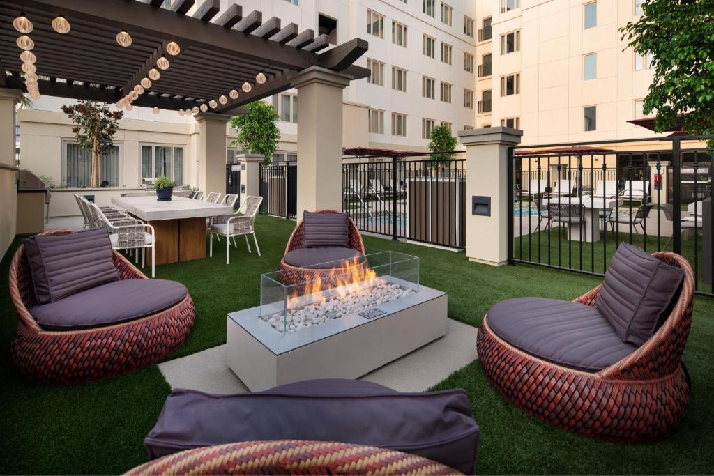 eine Terrasse mit einer Feuerstelle, Stühlen und einem Tisch in der Unterkunft Residence Inn Los Angeles Glendale in Glendale