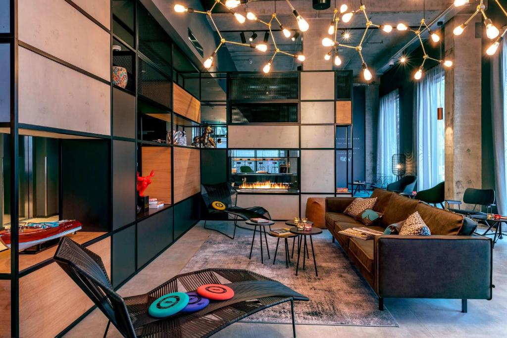 a living room with a couch and a table at Moxy Milan Linate Airport in Segrate